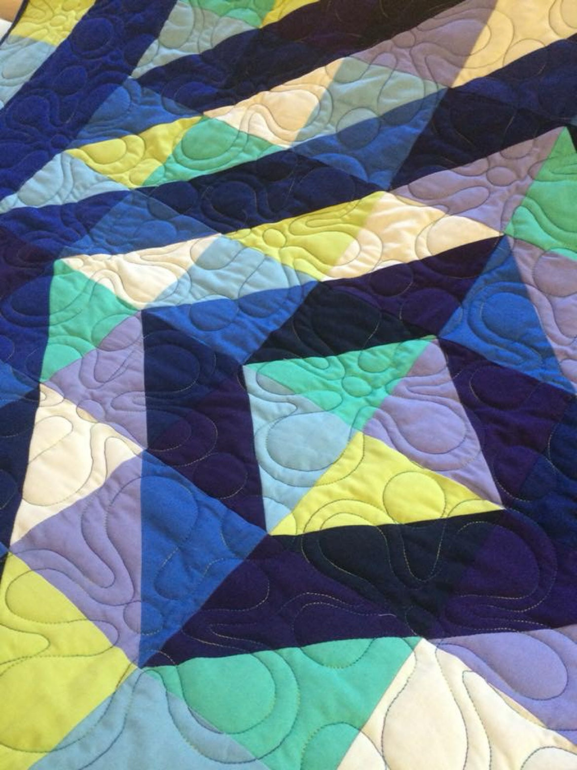 Full 14 foot APQS Millennium longarm frame with a quilt loaded for quilting